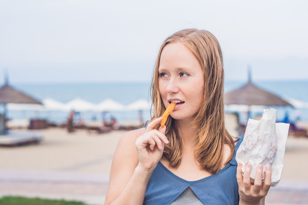 Frauen essen gebratene Süßkartoffeln im Park.