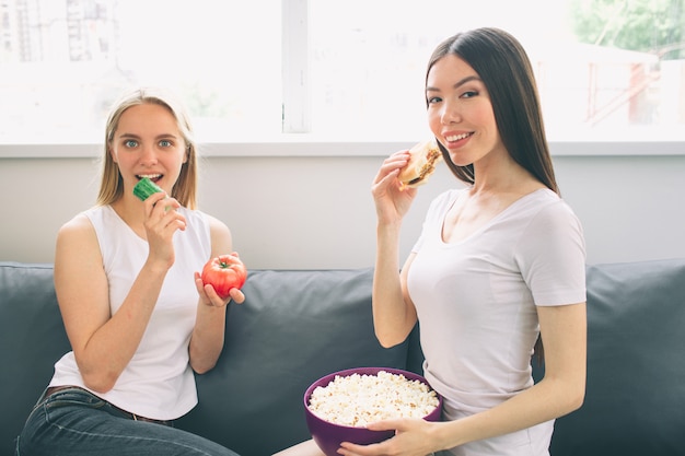 Frauen essen Popcorn und Gemüse