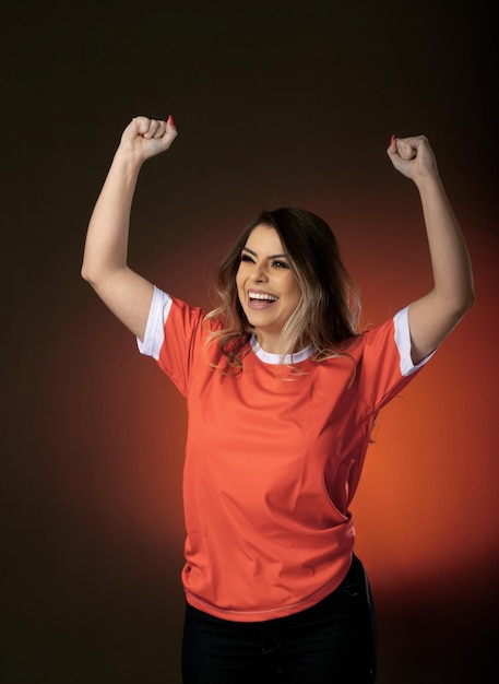 Frauen-Fußballfan jubelt ihrem Lieblingsclub und ihrem orangefarbenen Hintergrund der Team-Weltmeisterschaft zu