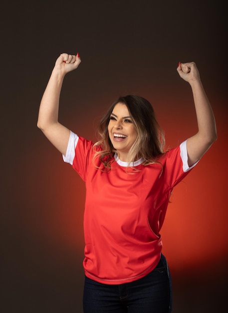 Frauen-Fußballfan jubelt ihrem Lieblingsclub und ihrem roten Hintergrund der Team-Weltmeisterschaft zu