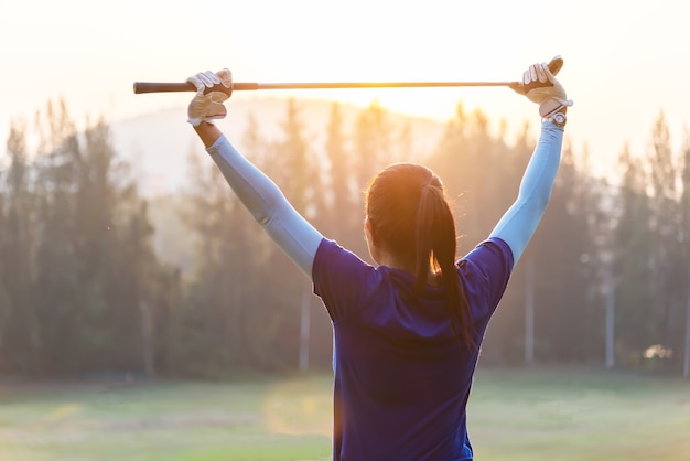 Foto frauen golfspieler verwenden von golfschlägern um zu helfen, körper vor dem spiel zu wärmen