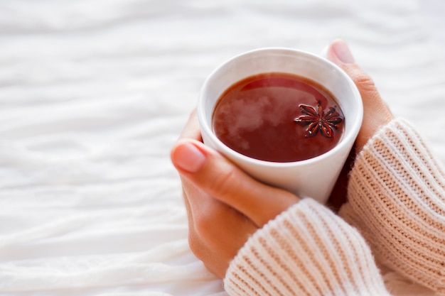 Frauen hält eine Tasse heißen Tee mit Anisstern