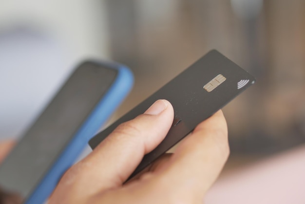 Foto frauen halten kreditkarte in der hand und nutzen smartphone-shopping online