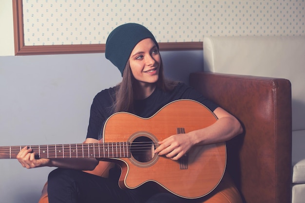 Frauen-Hipster, der auf Gitarre spielt und Musik genießt