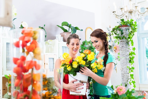 Frauen im Blumenspeicher die Rosen genießend