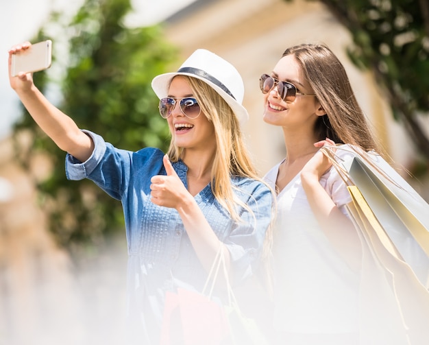 Frauen in der Sonnenbrille, die ein selfie mit ihrem Handy nimmt.