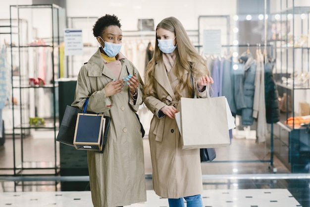 Frauen in medizinischen Masken einkaufen.