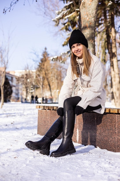 Frauen in weißen Wintermänteln und schwarzen Lederstiefeln Streetstyle lässige Damenmode Winter Damen Stil