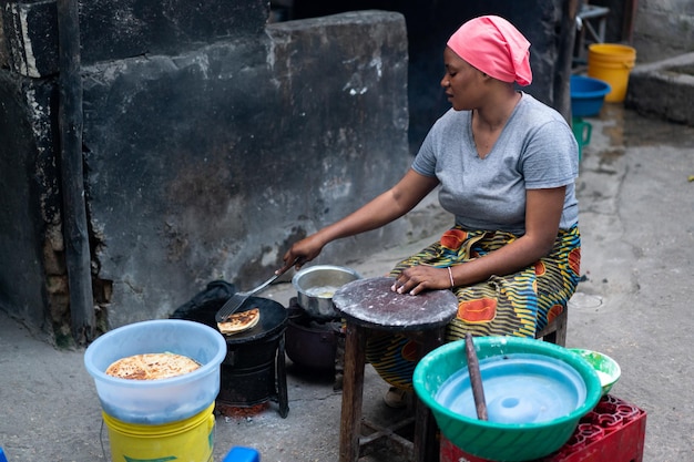 Frauen kochen draußen auf der Straße traditionelles Essen. Hochwertiges Foto