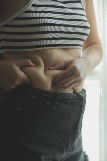 Foto frauen körperfett bauch fettleibige frau hand halten übermäßige bauchfett diät lebensstil konzept, um bauch zu reduzieren und bilden gesunde magenmuskeln