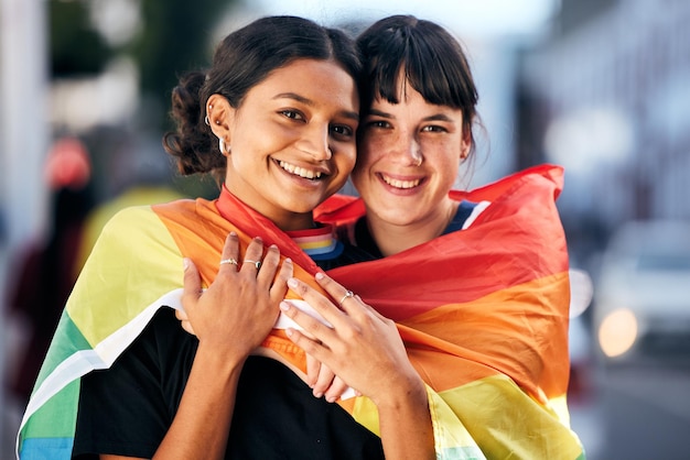 Frauen lgbtq und Porträt mit stolzer Flagge für Liebesgleichheit und Unterstützung in der Stadt Schwule Lesben und ein paar Freunde umarmen sich mit Regenbogenidentität, fröhlichem Gesicht und Freiheit bei der Menschenrechtsparade