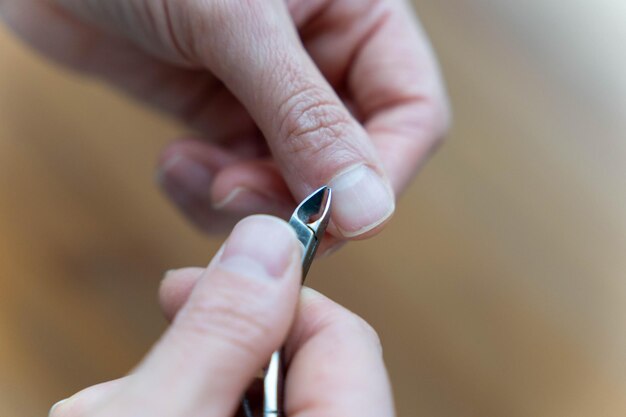 Frauen machen Maniküre, indem sie Kutikeln mit Nagelkniffern schneiden.