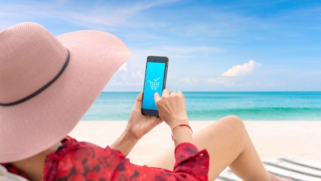 Frauen mit breitkrempigen Hüten Lehnen Sie sich an einem sonnigen Tag zurück und entspannen Sie am Strand