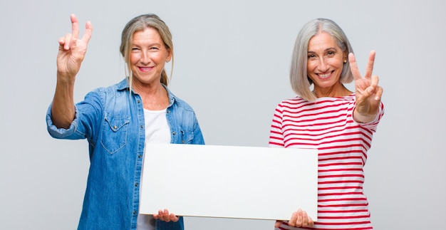 Frauen mittleren Alters lächeln und sehen glücklich aus