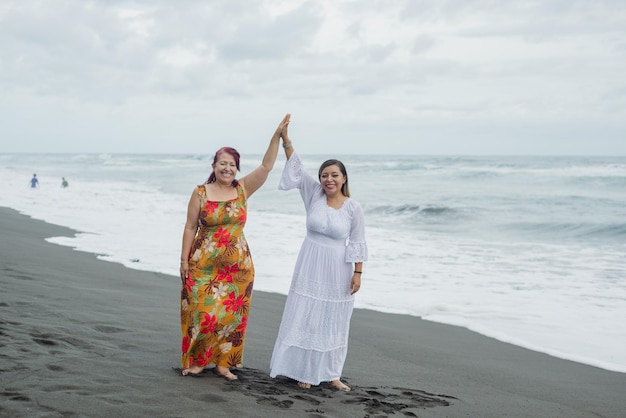 Frauen, Mutter und Tochter genießen Zeit am Strand. Pazifischer Ozean, bewölkter Tag.