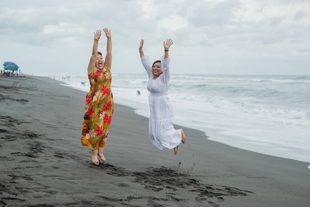 Frauen, Mutter und Tochter genießen Zeit am Strand. Pazifischer Ozean, bewölkter Tag.