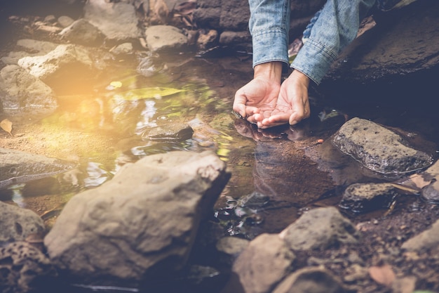 Frauen nehmen klares Wasser im Kleinen Bach