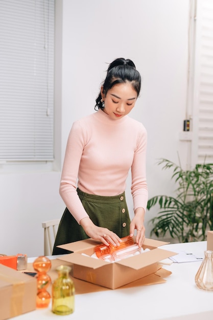 Frauen packen Pakete mit ihren Produkten, die sie online verkauft