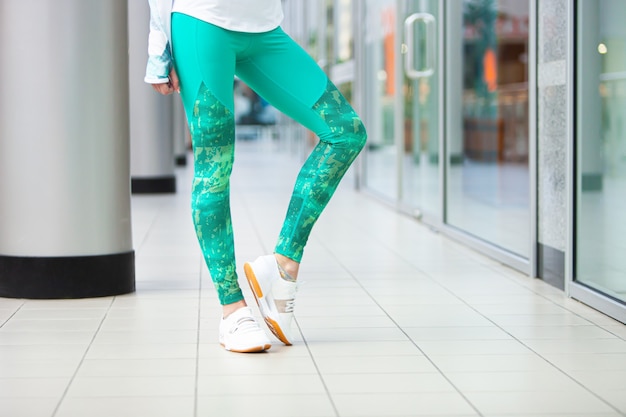 Frauen schlanke Beine in Sportleggings und Turnschuhen im Fitnessstudio.