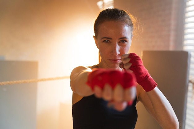 Frauen-Selbstverteidigung, Girl-Power, starke Kämpferin, die mit roten Boxbandagen schlägt, Sportschutz