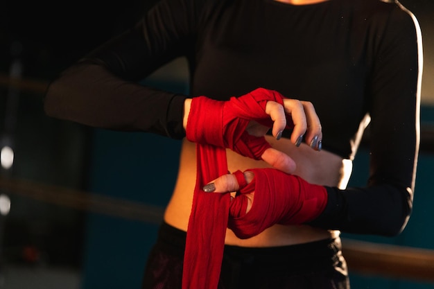 Frauen-Selbstverteidigungs-Girl-Power-Kämpferin, die sich auf den Kampf vorbereitet, der die Hände mit roten Boxpackungen umwickelt