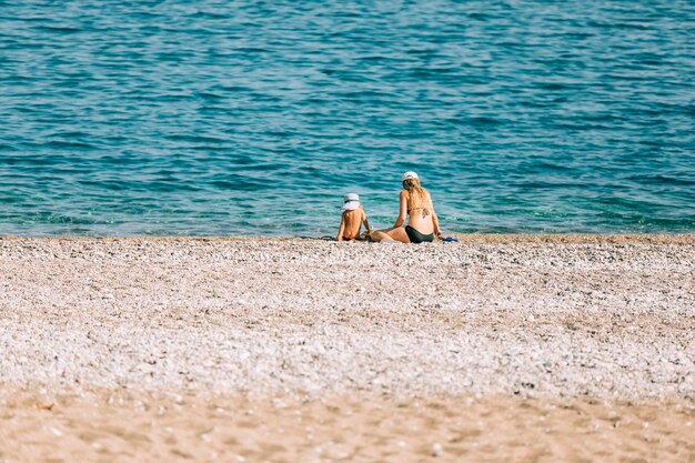 Foto frauen sitzen am ufer am strand