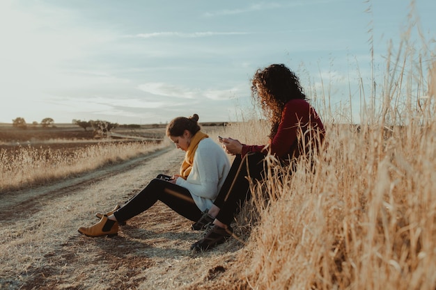 Frauen sitzen auf dem Feld gegen den Himmel
