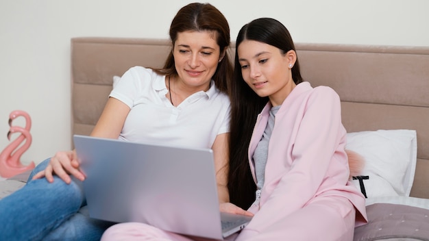 Frauen sitzen drinnen und benutzen den Laptop