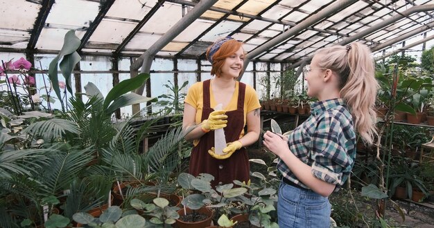 Foto frauen sprechen beim pflanzen im gewächshaus