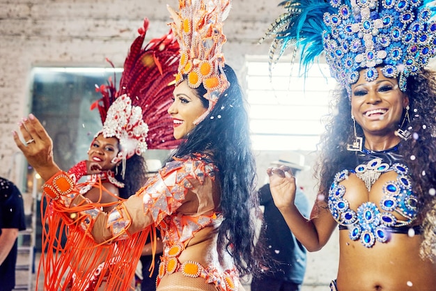 Frauen tanzen und Karnevalsmode bei brasilianischen Party-Events, festlichen Feiern oder Neujahrs-Salsa-Performance. Lächeln Sie glückliche Freunde und Samba-Tänzer und Feder-Accessoires oder Festival-Show-Kleidung