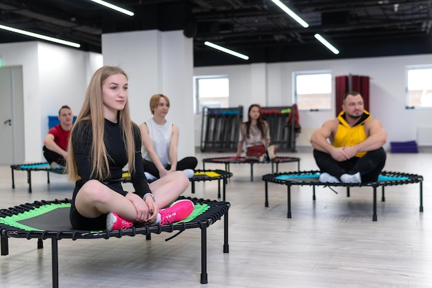 Frauen- und Männergruppe auf einem Sporttrampolin Fitnesstraining gesundes Leben ein Konzepttrampolin