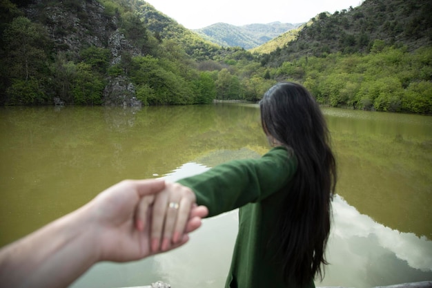 Frauen- und Mannhände im Seehintergrund