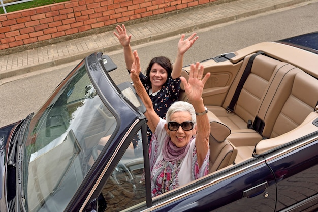 Frauen verschiedener Generationen freuen sich in einem Cabrio