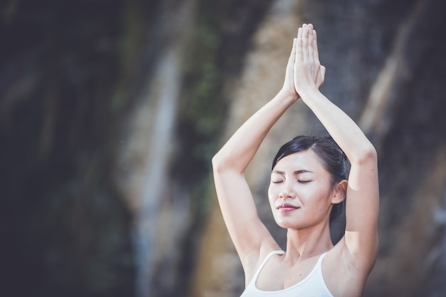 Frauen-Yoga - entspannen Sie sich in der Wasserfallnatur.