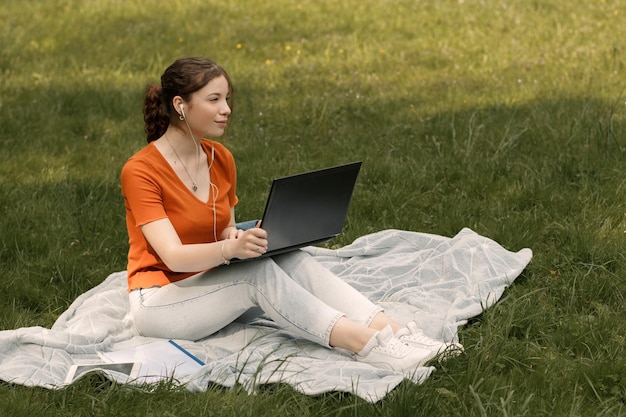 Frauenarbeit mit Laptop im Park