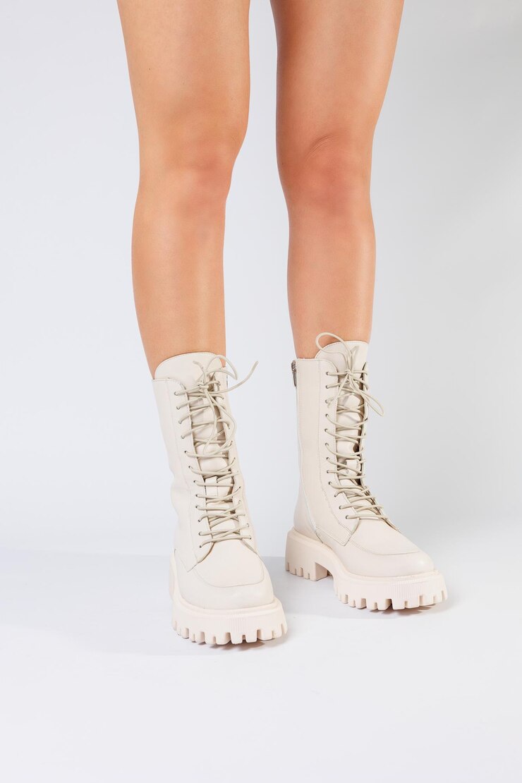 Frauenbeine in einer Sammlung modischer weißer Lederschuhe auf weißem Hintergrund Frühlingskollektion von Damenschuhen