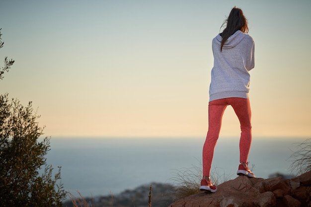 Frauenbeine in roten Leggings, die den Berg erklimmen