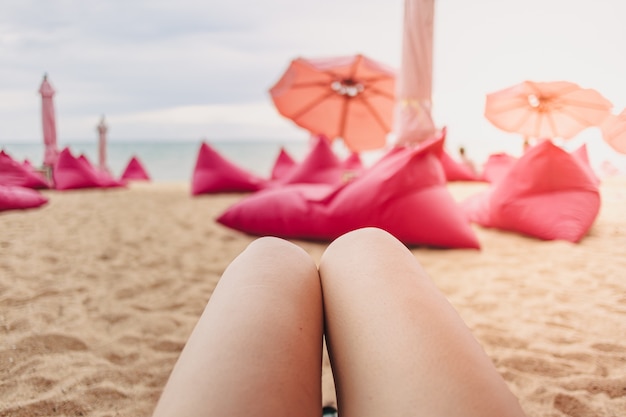 Frauenbeine mit Blick auf das Strandcafé-Konzept der Entspannung am Sommerstrand