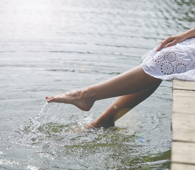 Frauenfüße tauchen ins Wasser und fühlen sich frisch