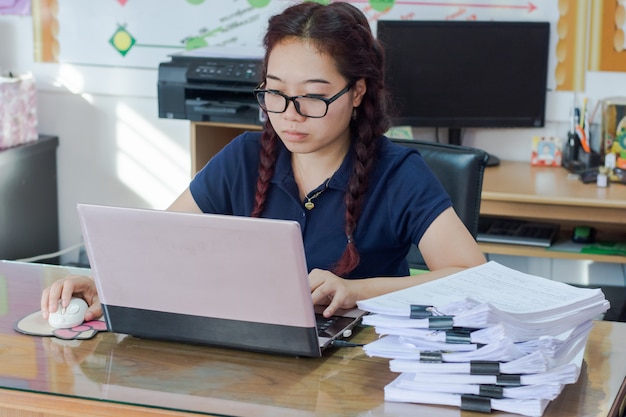 Frauengebrauch der Laptop-Computers und der drahtlosen Maus, des Webs, das auf Internet oder der Jobsuche grast