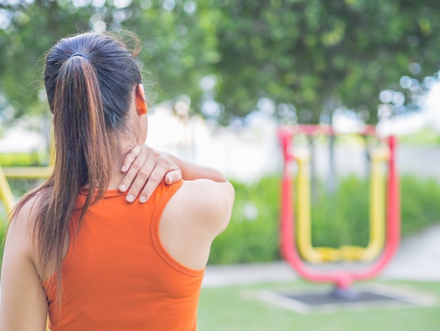 Frauengefühlsschmerz auf ihrem Hals und Schulter beim Trainieren, Gesundheitswesenkonzept.