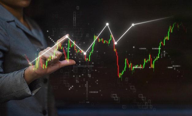 Frauengeschäft und -händler, die Aktiendiagramm zeigen