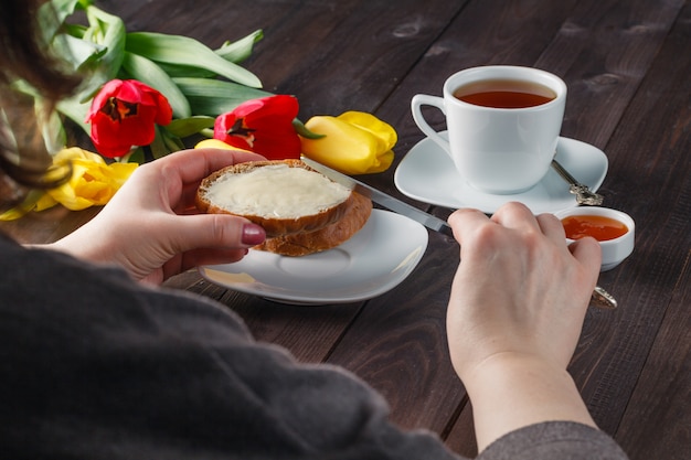 Frauenhände, die Brot buttering sind