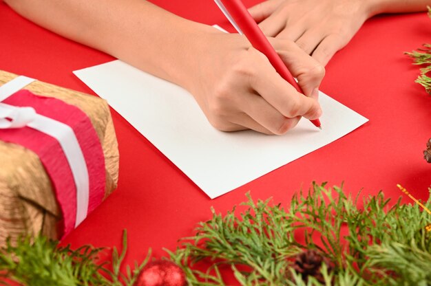 Frauenhände, die einen Brief für Weihnachten schreiben
