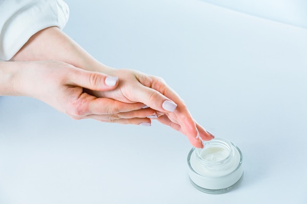 Frauenhände, die Feuchtigkeitscreme auf die Hände auftragen, stoppen den Alterungsprozess mit innovativer Behandlung