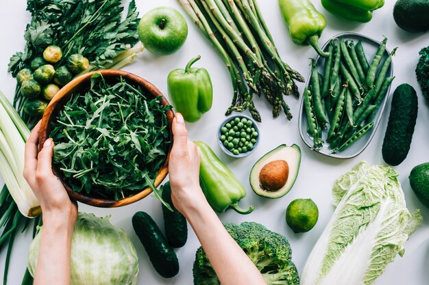 Frauenhände, die frischen Rucola in Holzschale nehmen, gesundes Ernährungskonzept. Salat kochen