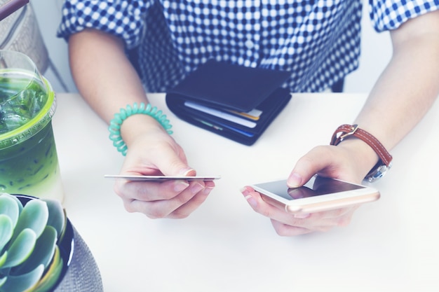 Foto frauenhände, die online-zahlung am intelligenten mobiltelefon und an der kreditkarte in der kaffeestube leisten