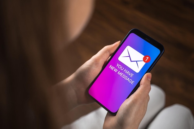 Frauenhände, die Smartphone mit neuem Nachrichtenkonzept auf dem Bildschirm halten Neues Geschäftshintergrundfoto für E-Mail-Benachrichtigungen