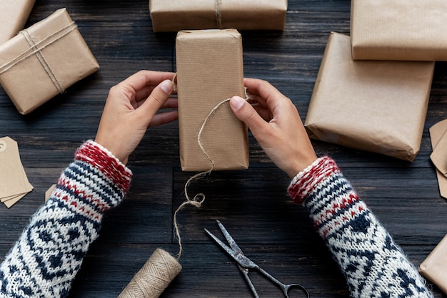 Frauenhände, die Weihnachtsgeschenkbox einhüllend