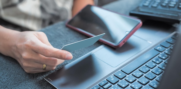 Frauenhände erledigen Online-Einkäufe zu Hause. Geeignet für die Erstellung von Infografiken